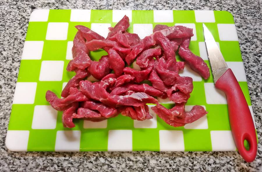 strips of beef on chopping board