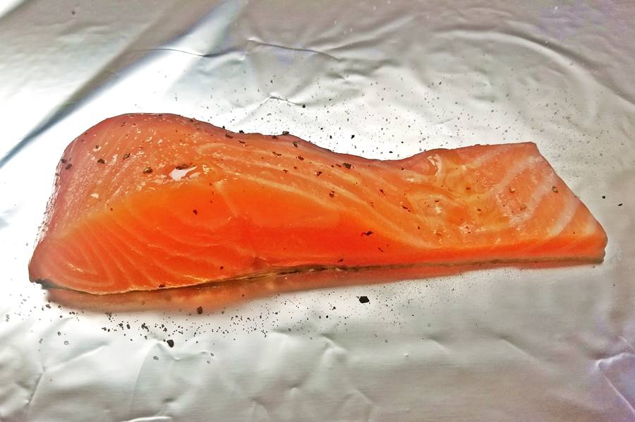 salmon slice raw salmon on aluminium foil, with salt pepper and olive oil