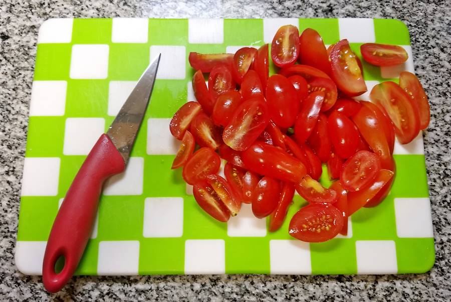 cherry tomatoes sliced on board