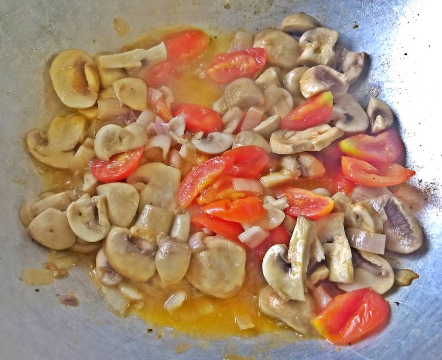 tomatoes, mushrooms and shallots simering in the wok