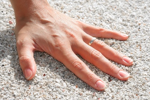 woman’s hand resting on white sand
