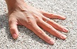 hand of a woman, palm down on white sand