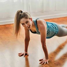 woman smiling in plank position exercising happily