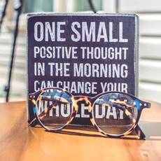 blackboard written with positive thoughts quote, eye glasses