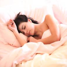 woman sleeping soundly on white sheets
